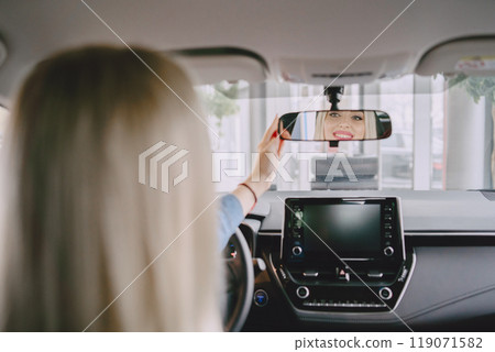 Lady in a car salon. Woman buying the car. Elegant woman in a blue dress. 119071582