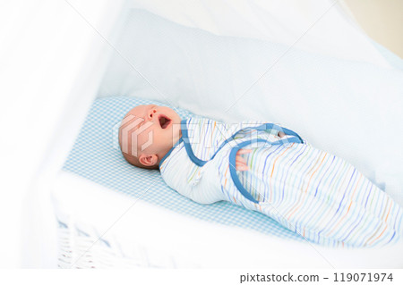 Swaddling newborn child. Baby in swaddle blanket. Swaddling newborn child. Baby in swaddle blanket. 119071974