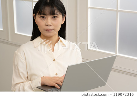 一位女士站著操作筆記型電腦 一位女士站著操作筆記型電腦 119072316