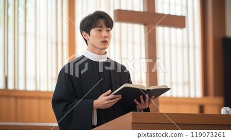 Korean Protestant Minister in Traditional Clerical Attire Preaching in a Church with Wooden Interior Design 119073261