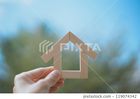 拿著木屋的人的手和綠色模糊背景 119074342