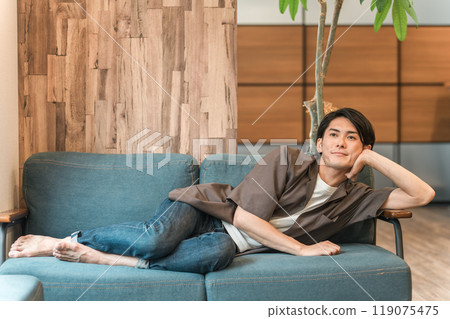 Young Asian man lying on the sofa Young Asian man lying on the sofa 119075475