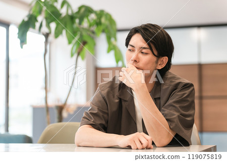 A young Asian man feeling depressed at a cafe (worrying, thinking, burnout syndrome, depression, apathy) A young Asian man feeling depressed at a cafe (worrying, thinking, burnout syndrome, depression, apathy) 119075819