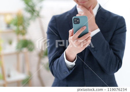 A man in a suit with a smartphone A man in a suit with a smartphone 119076234