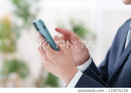 A man in a suit with a smartphone 119076236