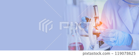 Banner Asian woman scientist hand write note research in medical lab look at science microscope. Panorama biology chemistry lab. Asian Female technician laboratory using microscope with copy space Banner Asian woman scientist hand write note research in medical lab look at science microscope. Panorama biology chemistry lab. Asian Female technician laboratory using microscope with copy space 119078625