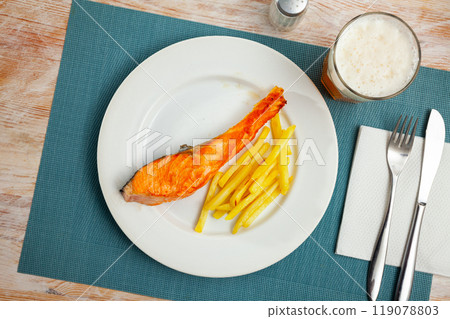 Grilled salmon fillet with garnish of baked potatoes 119078803