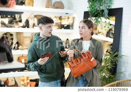 Couple man and woman choosing handbag and wallet in store 119078969