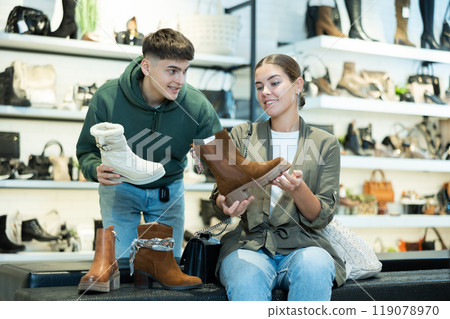Young couple shopping for comfortable fall footwear in shoe store 119078970