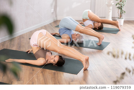 Young woman doing yoga in group in studio 119079359