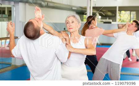 Woman self defense training gym learning to do painful grip Woman self defense training gym learning to do painful grip 119079396