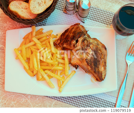Roasted chicken with fries served with glass of red wine Roasted chicken with fries served with glass of red wine 119079519