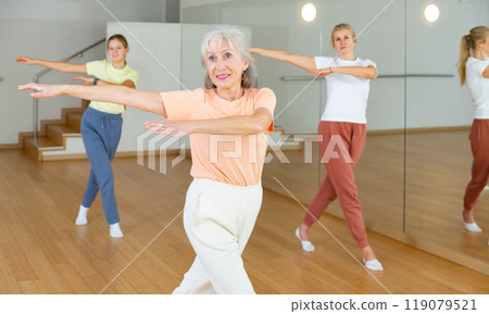 Ordinary females exercising dance moves in dance center 119079521