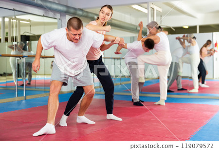Woman and man practicing self defense techniques Woman and man practicing self defense techniques 119079572