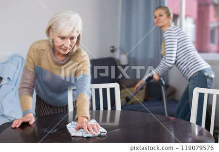 Mature woman and her adult daughter clean the room Mature woman and her adult daughter clean the room 119079576