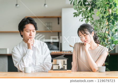 一對年輕夫婦正在查看房屋模型並考慮其房屋的平面圖(諮詢會議、房屋建築商、獨立式住宅) 一對年輕夫婦正在查看房屋模型並考慮其房屋的平面圖(諮詢會議、房屋建築商、獨立式住宅) 119079723