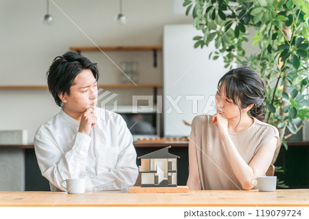 A young couple looking at a house model and considering the floor plan of their home (consultation meeting, house builder, detached house) 119079724