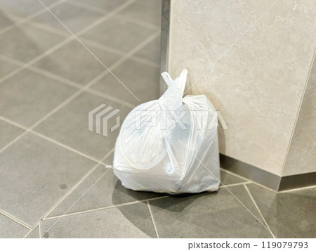 A plastic bag full of garbage in a public place 119079793