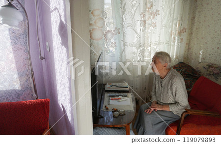 The senior woman watching tv at home. The senior woman watching tv at home. 119079893