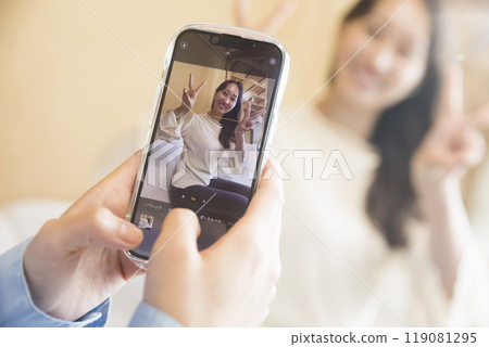 一位女士用智慧型手機為她的朋友拍照 119081295