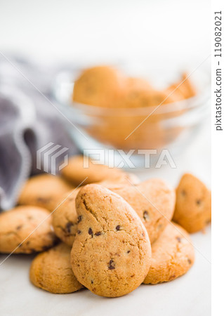 Biscotti frollini con gocce di cioccolato. Chocolate cookies on kitchen table. 119082021