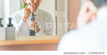 一位身穿西裝的年輕亞洲商人早上上班前在浴室刮鬍子 119082910