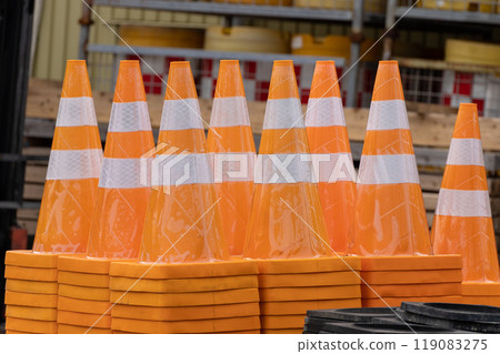 Vermilion traffic cones with white lines lined up and stacked Vermilion traffic cones with white lines lined up and stacked 119083275