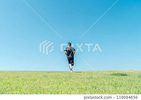 A man running/jogging under a blue sky (athlete/aerobic exercise/workout/fitness) 119084656