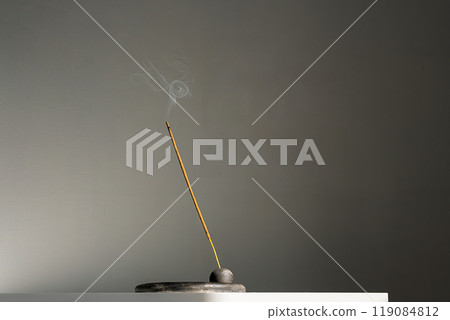 Burning incense stick and smoke with contrast shadows. 119084812