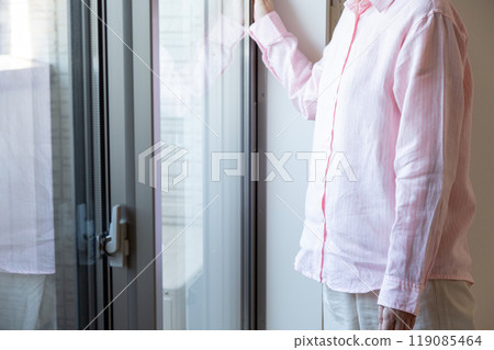 站在公寓窗邊的中年婦女 站在公寓窗邊的中年婦女 119085464