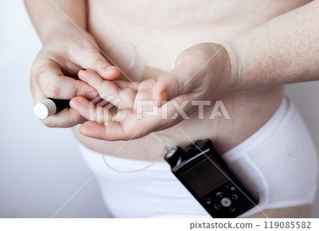 Person checking blood sugar level with diabetes monitor device 119085582