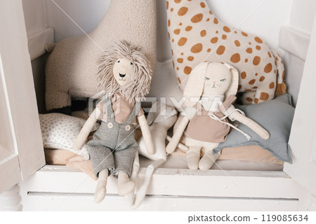 Stuffed animals, one of which is a giraffe, sit on children bed Stuffed animals, one of which is a giraffe, sit on children bed 119085634