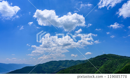 初夏的藍天下，山頂飄過許多白雲 119085778