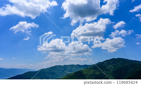 Under the blue sky of early summer, many white clouds float over the mountaintop Under the blue sky of early summer, many white clouds float over the mountaintop 119085824