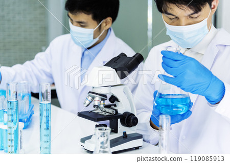 Scientist man look into Microscope research in science laboratory. Asian scientist looking equipment laboratory chemistry labs. Covid-19 coronavirus biochemistry research experiment vaccine concept 119085913