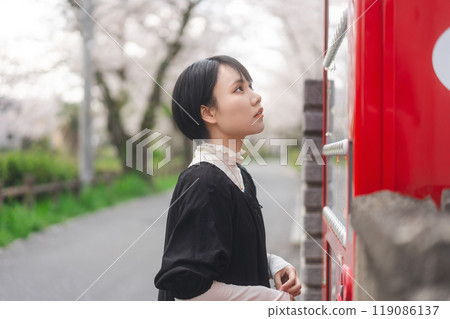 Asian woman consumer using japanese vending machine sakura pack backgroud in Tokyo, Japan Asian woman consumer using japanese vending machine sakura pack backgroud in Tokyo, Japan 119086137