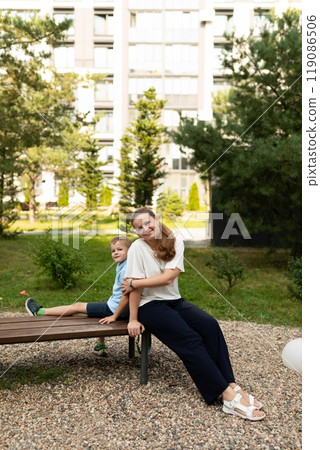 A joyful afternoon in the garden with mother and son enjoying their close-knit bond while relaxing A joyful afternoon in the garden with mother and son enjoying their close-knit bond while relaxing 119086506
