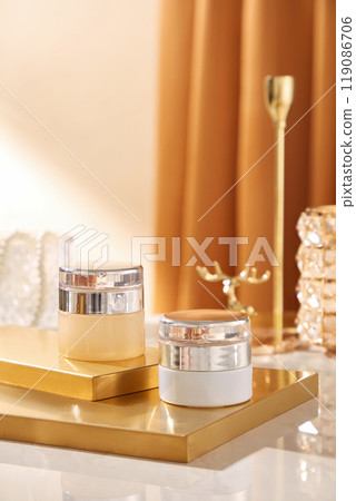 The chic backdrop picture template is ideal for advertising cosmetics. It features two skincare mockup positioned on copper platforms with ornaments surrounding them. The chic backdrop picture template is ideal for advertising cosmetics. It features two skincare mockup positioned on copper platforms with ornaments surrounding them. 119086706