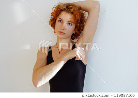 young woman uses hygiene product, roll-on deodorant 119087106