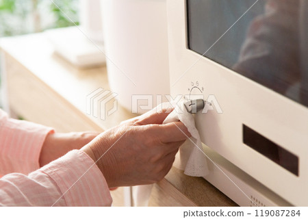 The hands of a middle-aged woman cleaning a microwave oven The hands of a middle-aged woman cleaning a microwave oven 119087284