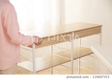 中年婦女將新的廚房架搬到廚房 119087353