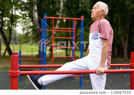 Elderly sportive man doing parallel bars exercise in park Elderly sportive man doing parallel bars exercise in park 119087839