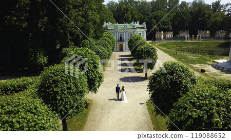Top view of newlyweds in garden. Creative. Couple of newlyweds are walking in palace garden. Rich newlyweds on their wedding day in garden of ancient estate Top view of newlyweds in garden. Creative. Couple of newlyweds are walking in palace garden. Rich newlyweds on their wedding day in garden of ancient estate 119088652