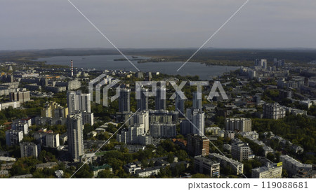 City with high-rise buildings on background of lake and green forest. Stock footage. Modern buildings in beautiful green city with lake and forest horizon. Top view of panorama of modern city in City with high-rise buildings on background of lake and green forest. Stock footage. Modern buildings in beautiful green city with lake and forest horizon. Top view of panorama of modern city in 119088681