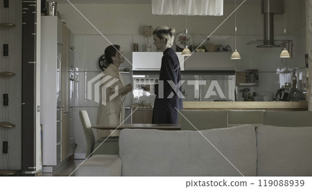 Young woman is talking to man who is walking away. Stock. Beautiful young couple is talking and shy. Young man in love is shy of woman in conversation 119088939