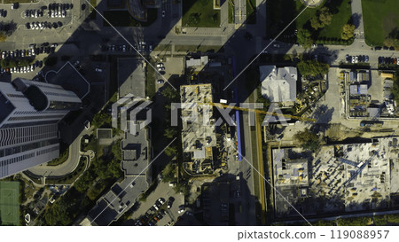 Vertical top view of construction crane in city. Stock footage. Building under construction in center of modern city on sunny summer day. Construction crane in city center Vertical top view of construction crane in city. Stock footage. Building under construction in center of modern city on sunny summer day. Construction crane in city center 119088957