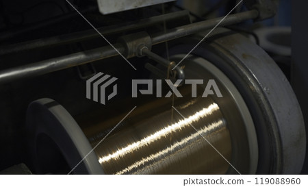 Close-up of coil winding copper wire. Creative. Shiny copper wire is wound on coil at metallurgical plant. Production of copper wires Close-up of coil winding copper wire. Creative. Shiny copper wire is wound on coil at metallurgical plant. Production of copper wires 119088960