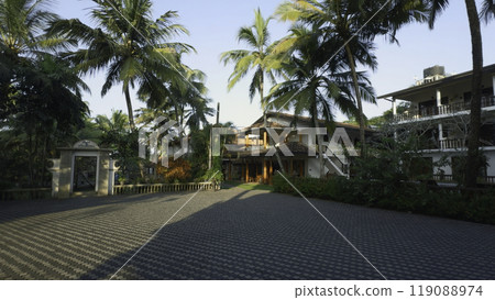 Beautiful exterior of cozy villa with palm trees. Action. Beautiful villa with wooden beams in exterior. Rent villa with palm trees on vacation in tropics 119088974