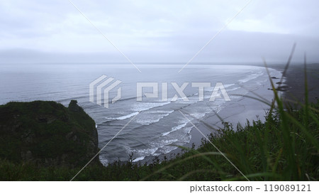 View with beautiful green grass on cliff of sea coast. Clip. Landscape of rocky coast with green grass and sea horizon on cloudy day. View from mountain coast to beautiful waves on summer day View with beautiful green grass on cliff of sea coast. Clip. Landscape of rocky coast with green grass and sea horizon on cloudy day. View from mountain coast to beautiful waves on summer day 119089121