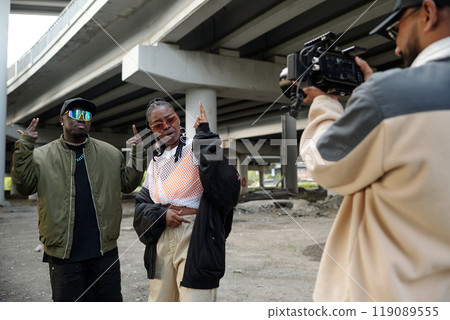 Filming Scene Under Urban Overpass Featuring Diverse Individuals 119089555